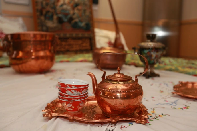 red ceramic teapot on green table